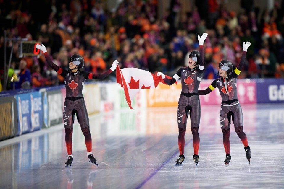 Carolina Hiller of Prince George, left, celebrates with sprint teammates Brooklyn McDougall and Ivanie Blondin after they won gold for Canada Thursday at the ISU Speed Skating World Championships in Heerenveen, Netherlands.