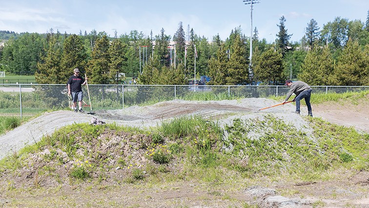 Citizen Photo by James Doyle/Local Journalism Initiative. Volunteers work to remove weeds and smooth out the dirt at Supertrak BMX track on Saturday morning. 