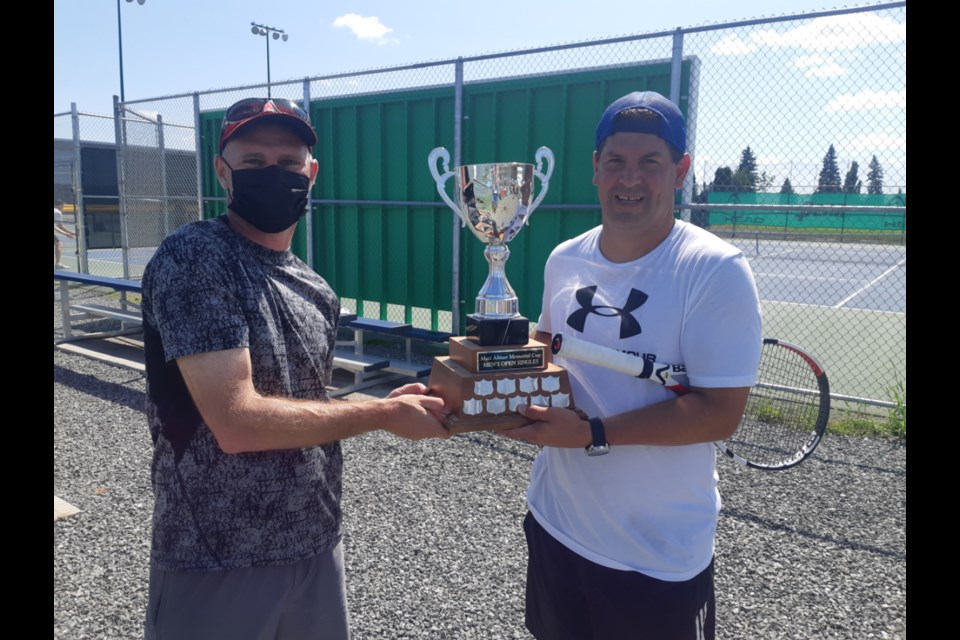 Prince George Tennis and Pickleball Club president Sean Margison, left, presents the Matt Altizer Memorial Cup to Jon LaFontaine after he defeated Thomas Taggert in thee sets to win the open singles tennis title Sunday at the club courts.