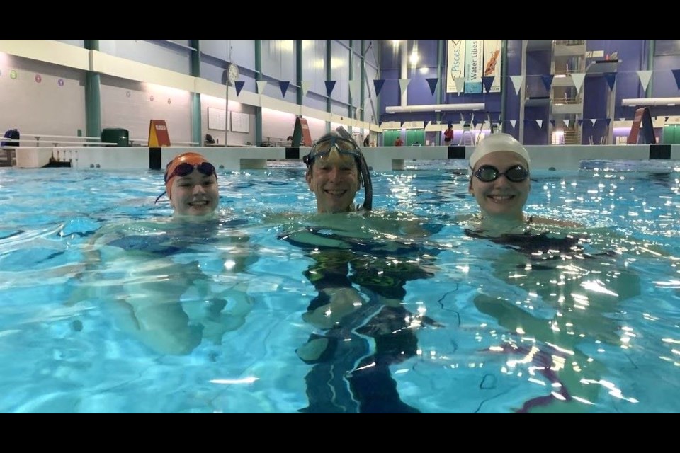 UNBC prof, 59, Stephen Rader, coach, mentor, and player, is seen here with the university's underwater hockey team Captain Naomi Cole, left and Assistant Captain Ella Stratton.