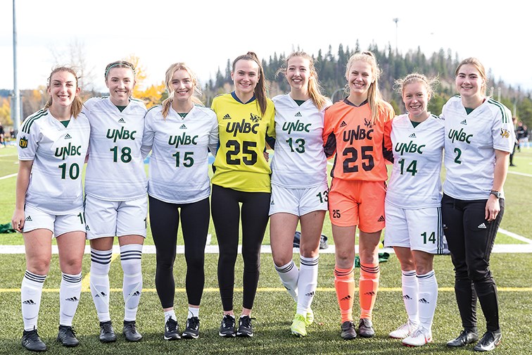 Citizen Photo by James Doyle/Local Journalism Initiative. Graduating players Sonja Neitch, Hallie Nystedt, Sarah Zuccaro, Madison Doyle, Brooke Molby, Mikaela Cadorette, Kierstin Vohar, and Grace Gillman pose for a photo after their final game in a UNBC Timberwolves jersey on Sunday afternoon at Masich Place Stadium.