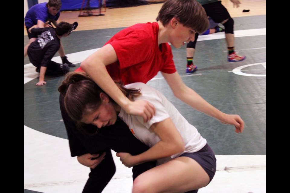 Amy Giesbrecht, 13, goes low for the takedown against her 14-year-old brother Zack during a Prince George Wrestling Club practice last week at Prince George Secondary School.