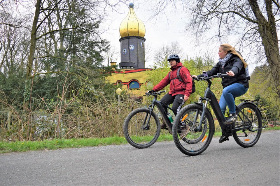 Cyclists pedal by the dome of the most distinctive Ronald McDonald House in the world along the Gruga-Trasse in Essen, Germany.