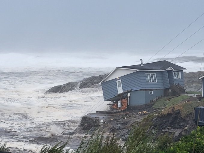 A house sits precariously overlooking the ocean at Port aux Basques, Nfld., after it took a direct hit from the storm surge whipped up Saturday by hurricane Fiona. 