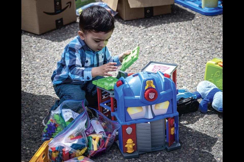 Two-year-old Abrahim Khan finds some goodies to play with at the REAPS Junk in the Trunk at CN Centre Saturday, May 10, 2025. 