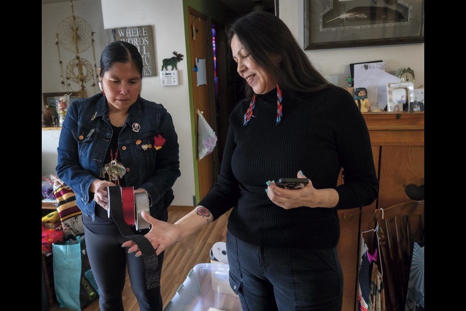 Seasmtress Tracy Peters shows Kym Gouchie the ribbon she will be using for her Juno Awards dress as they discuss how it will all come together in Kym's dining room Friday, March 21, 2025. Gouchie has been nominated for a JUNO award for Children's Album of the Year.
