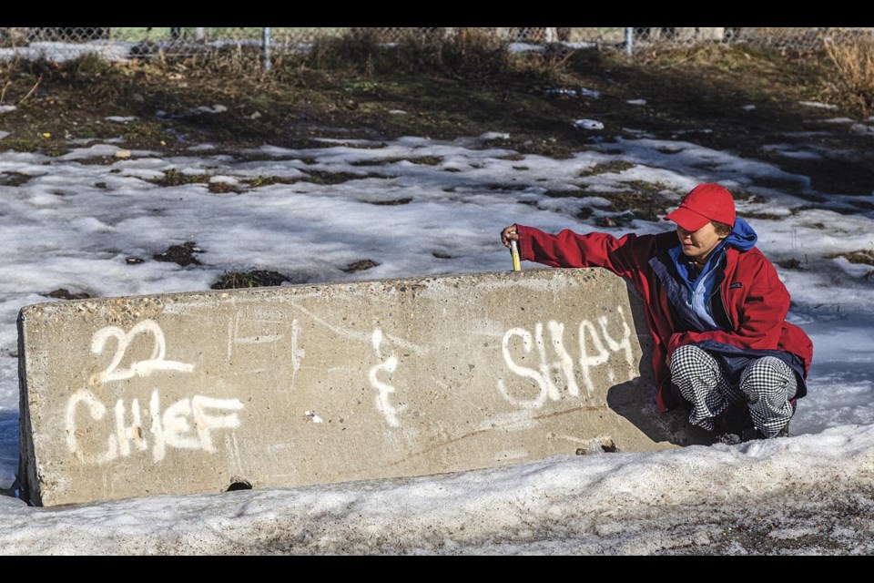 Terra Tyle, 40, sits by a painted reminder of her cat Shay while visiting Moccasin Flats Monday March 3. Tyle no longer stays at the Patricia Boulevard encampment but has no fixed address.