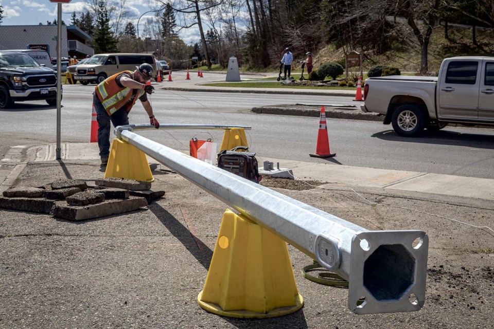 A worker from K2 Electric prepares to wire and erect a crosswalk light at the intersection of Queensway and Patricia Boulevard Thursday April 24, 2025. The right lane on Queensway at Patricia Boulevard and the right turn lane, coming off Patricia Boulevard onto Queensway will remain closed until  Friday, May 2nd when the work is expected to be done.