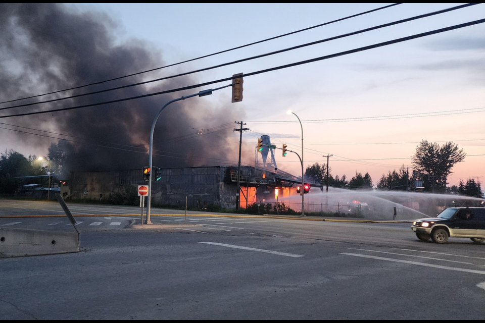 Fire crews hose down a section of the East Fraser Fibre mill in Quesnel, BC on Saturday, June 21, 2025.