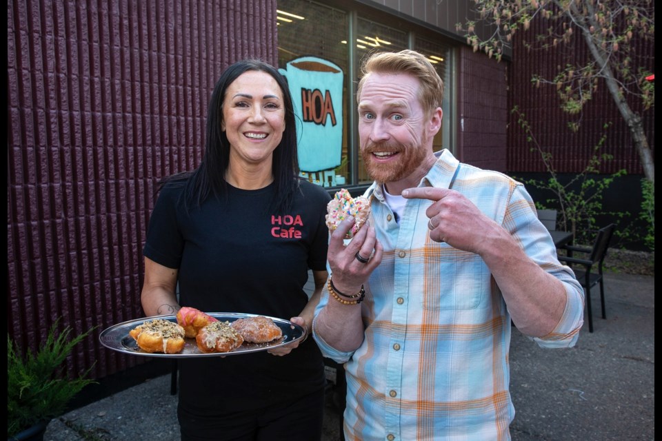 Jon Montgomery, host of The Amazing Race Canada, tries a House of Ancestors donut while shooting an episode of the series in Prince George in May 2025. 