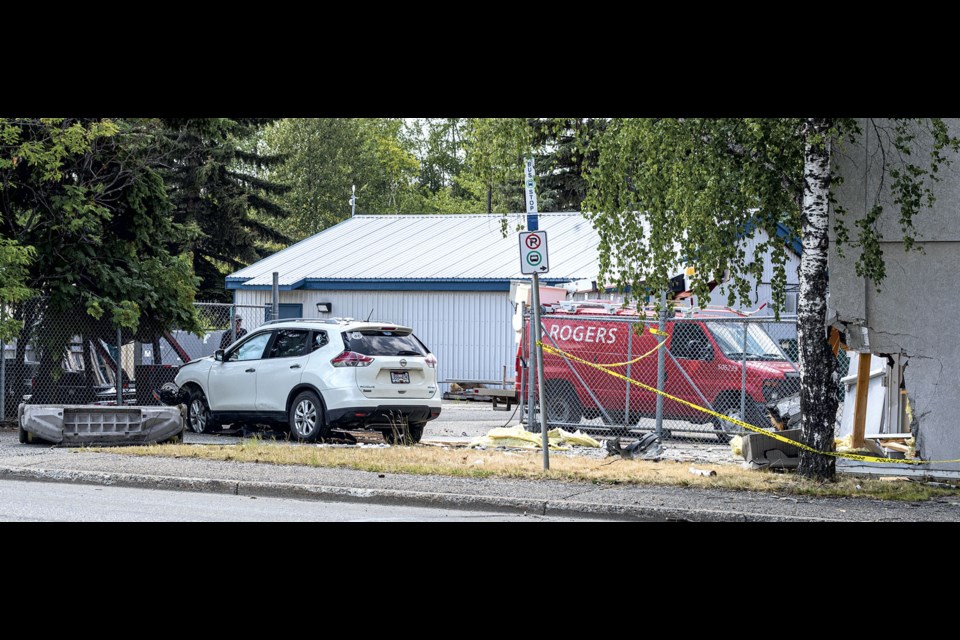 An SUV can be seen after it came to rest against a fence after colliding with a corner of the Rogers building on Queensway Saturday, July 27, 2024 in Prince George, B.C.