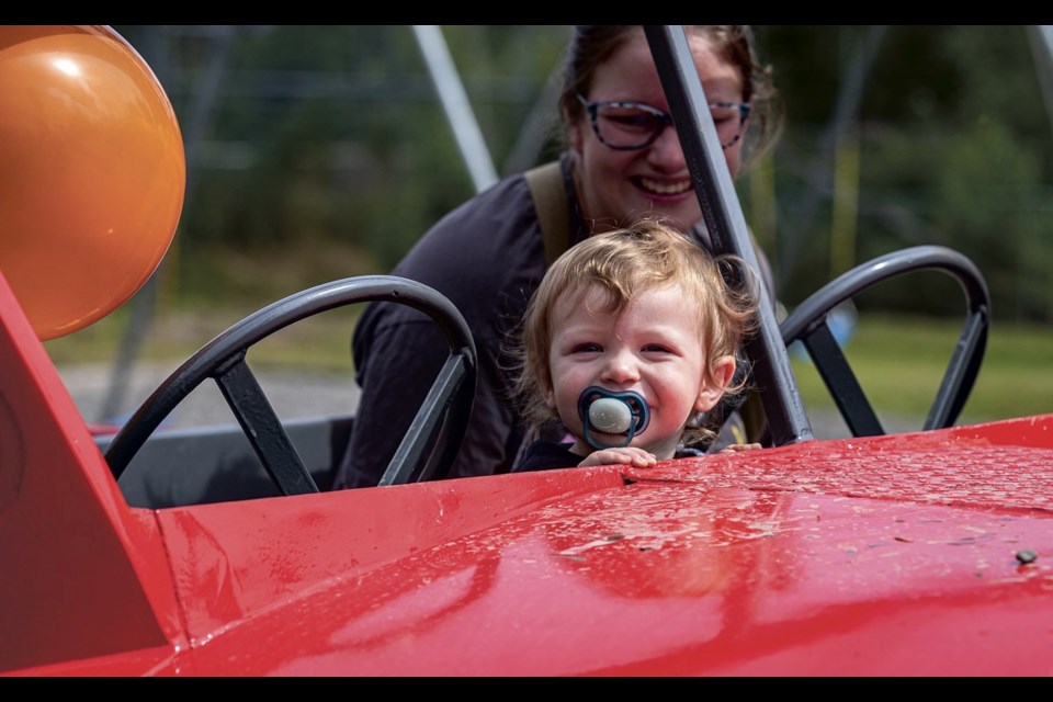 Jasper Lewis, 19 months old, smiles with the joy of climbing on the newly restored and installed fire truck with mom Kassandra at Shell-Glen Community Park Sunday, Aug. 10, 2025.