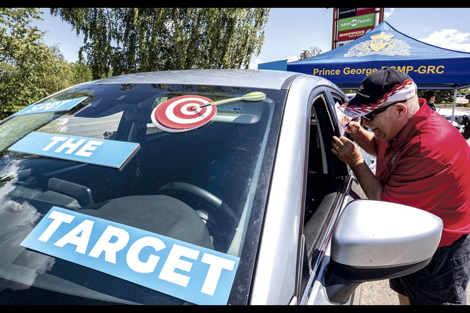 Chris Smith looks into a parked vehicle Wednesday at Pine Centre Mall to see how many potential targets he can can find that might encourage thieves to break into a vehicle. Smith was taking part in the Spot The Target display, a joint initiative with ICBC and RCMP where you have the chance to see if you can spot all of the potential targets that are often left inside a vehicle when parked. Smith managed to find eight of 10 potential targets.