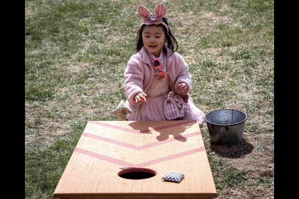 Five-year-old Leah Hwang has fun seeing how many times she can score on the Bean Bag Toss at the Spring into Easter event at Northern Lights Winery Easter Sunday, April 20, 2025.