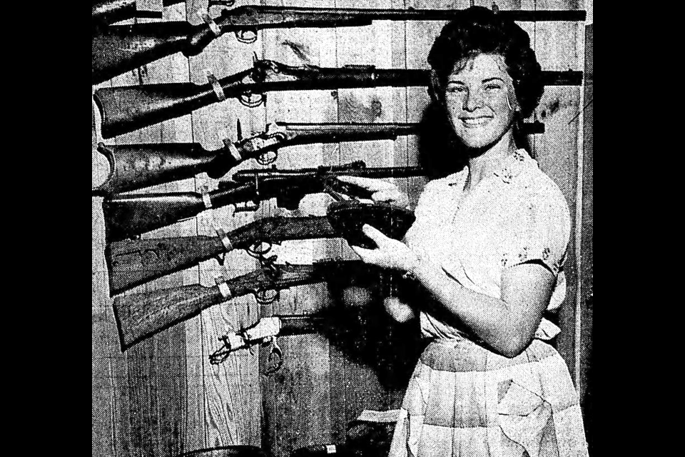 June 28, 1961: Pat Turner of the tourist bureau here examines an iron used by a pioneer woman in the area and undoubtedly wonders how anyone could have mastered housework in the “good old days.” The iron is one of many household articles and other links with the past in the collection stored in the chamber of commerce building and owned by the Prince George Historical Society. In the background are rifles used by pioneers in the area