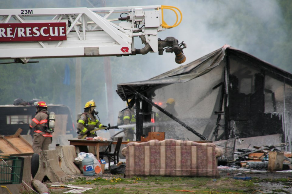 Firefighters battle a blaze at Moccasin Flats on Thursday, May 30, 2024 in Prince George, B.C. It was the second fire at the homeless encampment on Lower Patricia Boulevard this week.