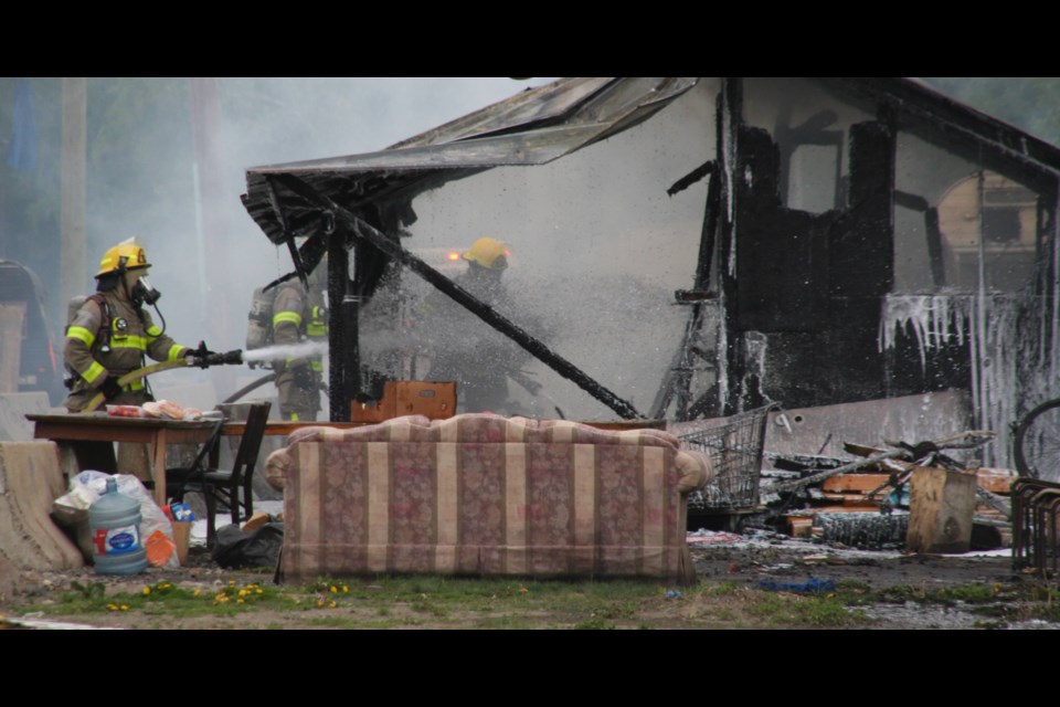 Firefighters battle a blaze at Moccasin Flats on Thursday, May 30, 2024 in Prince George, B.C. It was the second fire at the homeless encampment on Lower Patricia Boulevard this week.