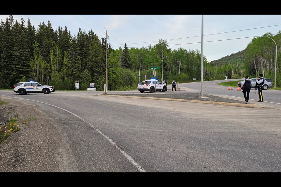 Prince George RCMP officers set up at the intersection of Highway 16 and Upper Fraser Road east of the city on Tuesday, May 27, 2025. The highway was closed as police, including an emergency response team, dealt with a developing situation.
