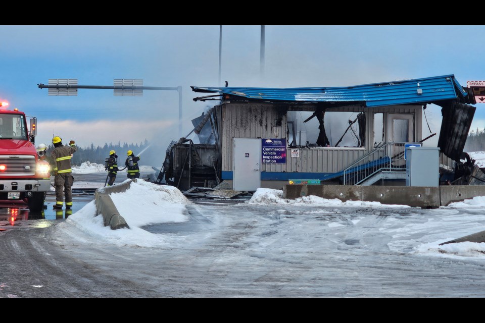 Volunteer firefighters battle a blaze at the Red Rock weigh scales on Highway 97 south of Prince George, BC on Tuesday, Dec. 24, 2024.