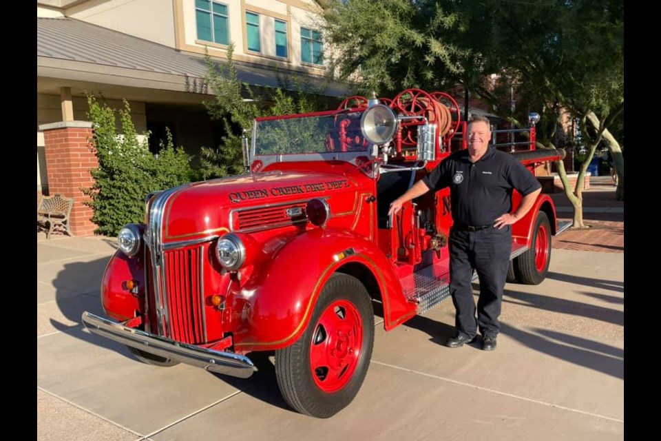 Queen Creek Fire and Medical Department Fire Chief Vance Gray with the department's new antique fire truck they restored over the summer.