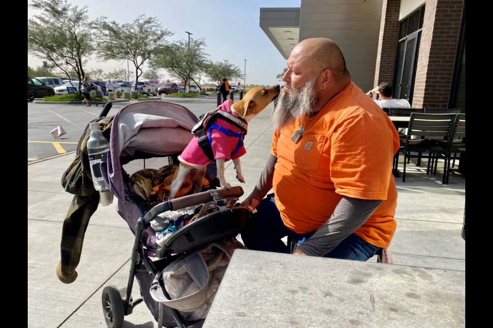 Johnnie Cardoza, 55, with his dog, Molly, outside Safeway in Queen Creek during March 2022.