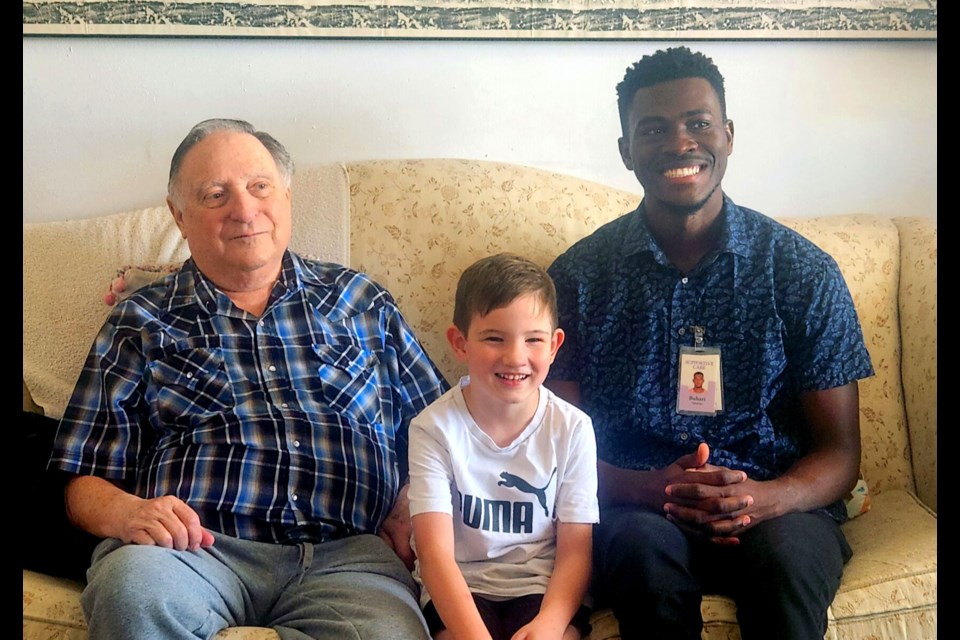 Volunteer Buhari Abdulai enjoyed providing companionship to patient Bill Harris and his grandson, David. 