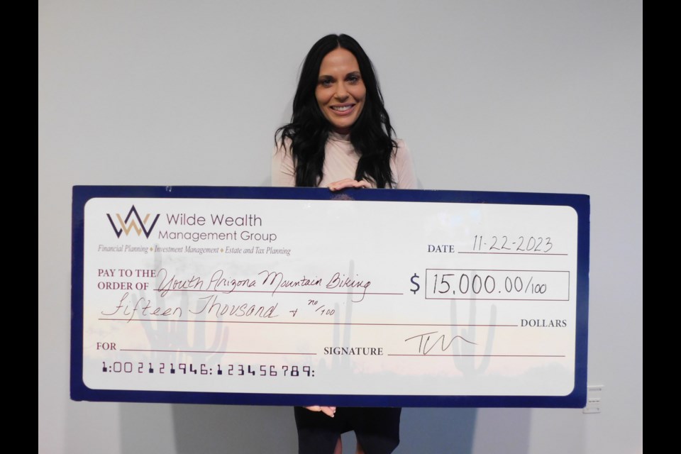 Wilde Wealth Management Group COO Jackie Yoder with the check donation.