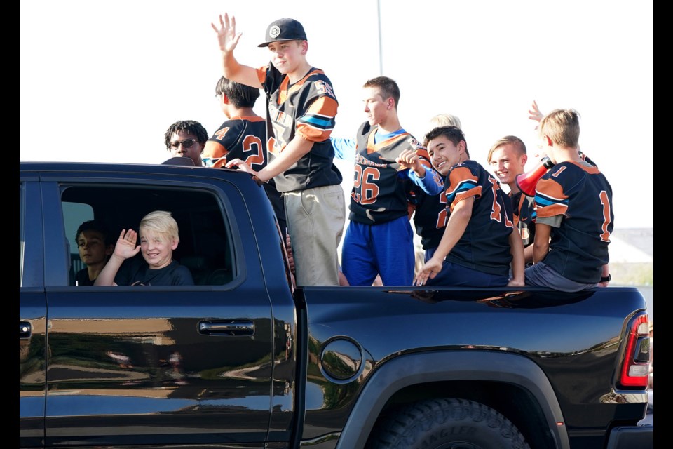 Eastmark High School football players wave to spectators during their first-ever homecoming parade on Friday, Sept, 17, 2021. Firebirds beat the Dysart Devils 50-13. 
Darryl Webb/Ifotouwebb.com