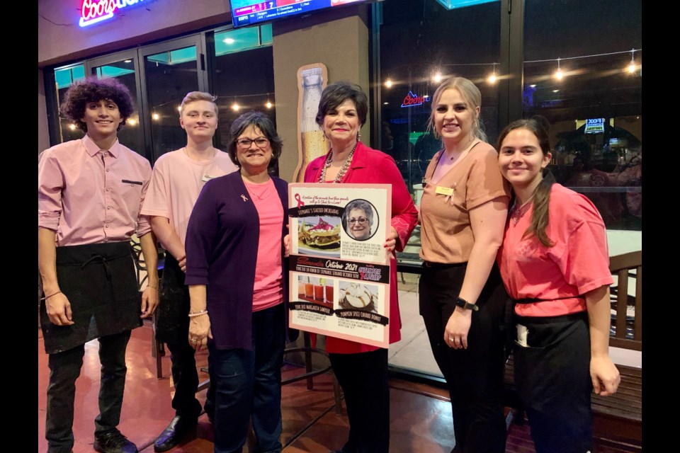 Sisters Carolyn Serrano (left middle) and Lisa Chaves (right middle) pose with Serrano’s employees at the 2021 Pink Out in memory of Stephanie Serrano.