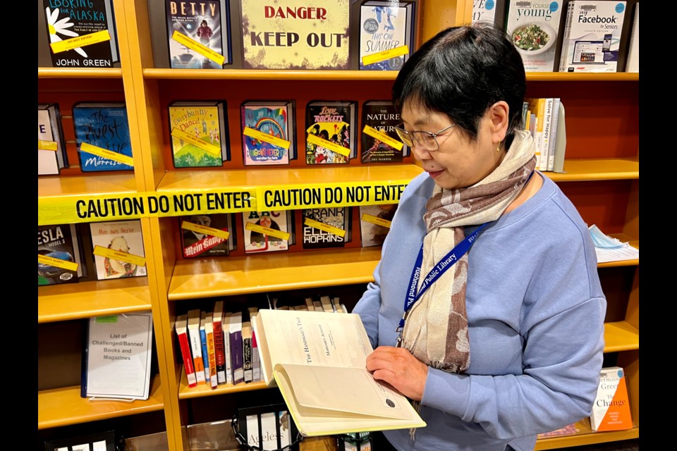 Librarian Wendy Jang reading Margaret Atwood's The Handmaid's Tale.