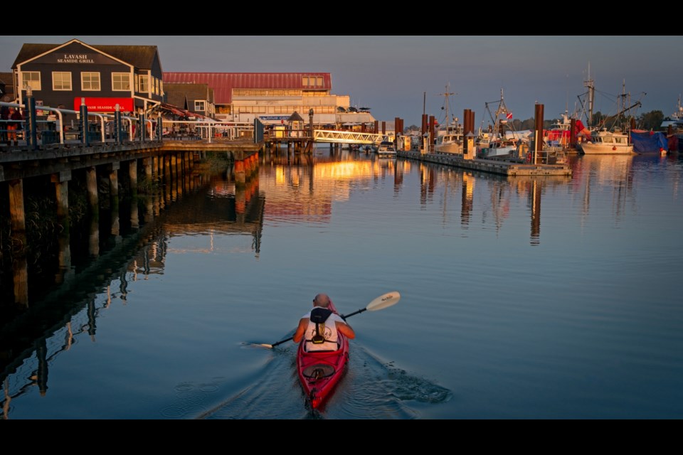 A person kayaking during sunset in Steveston.