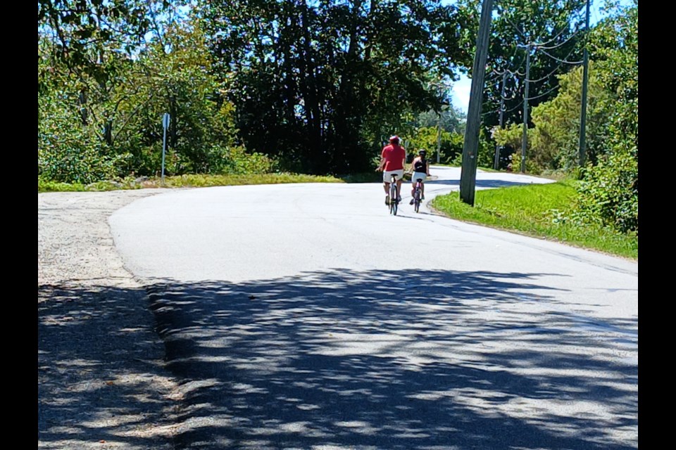 A couple cycling along a winding road on Dyke Road.