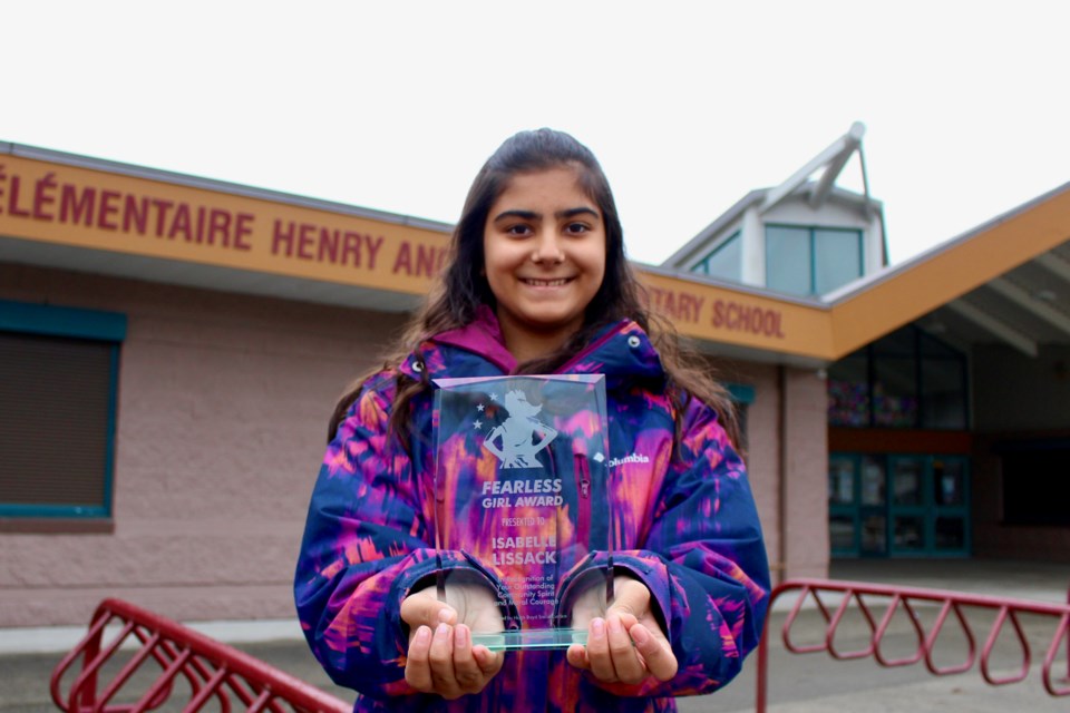 Isabelle Lissack posing with her award outside Anderson elementary.