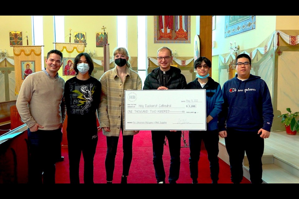 Grade 12 students from Hugh Boyd Secondary School’s social justice class presented cheque to father Mykhailo Ozorovych, the pastor at Holy Eucharist Ukrainian Catholic Cathedral. 