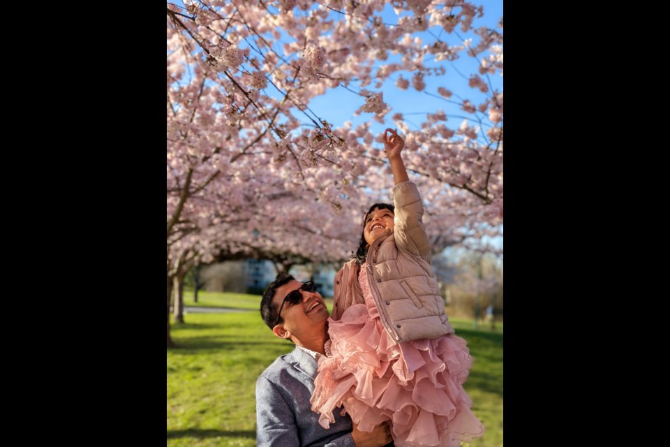 Aditya Chourasiya's photo features  him helping his daughter touch the cherry blossom petal at the Garry Point Park. 