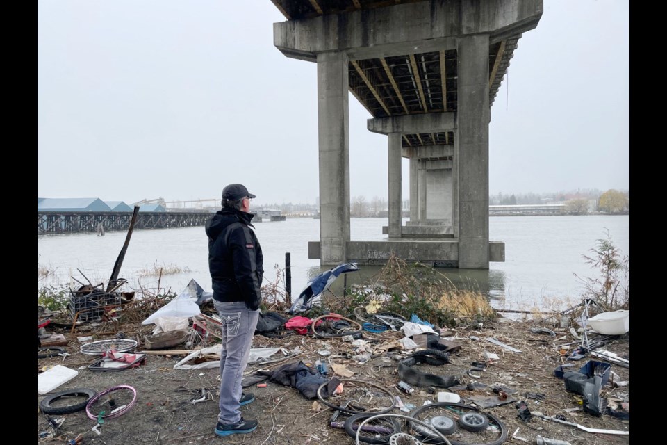 Hugh Freiberg surveys the remnants of a homeless camp under the Oak Street Bridge