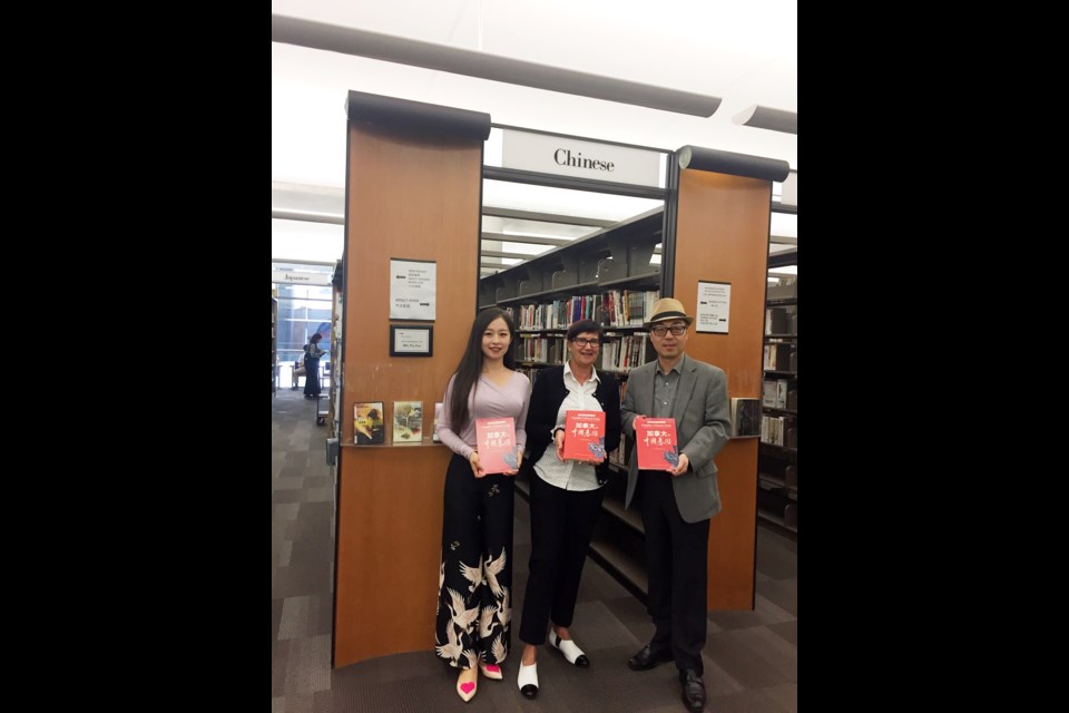 Kenny Zhang (right) donated books to the Vancouver Public Library when the book's original copy was published in Chinese in 2017. 