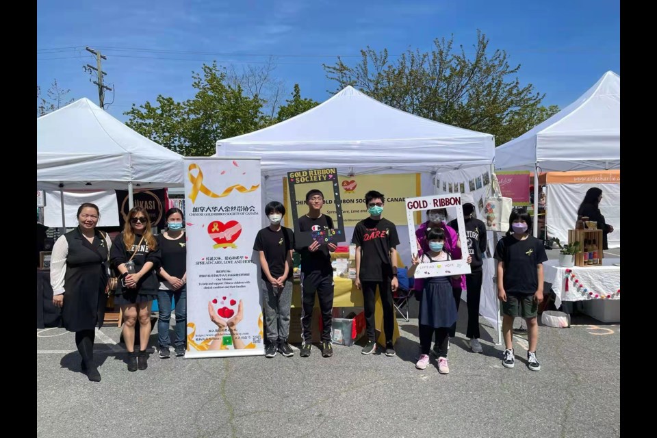 Volunteers from Gold Ribbons set up tent and wishing walls at the Steveston's farmers and artisans market to raise funds for children battling cancer. 