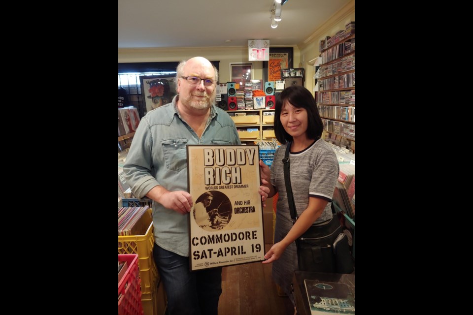 SOS Children's Village Store manager Yasmin Tang (right) with Rob Frith, of Neptoon Records, as he donates back the stolen poster