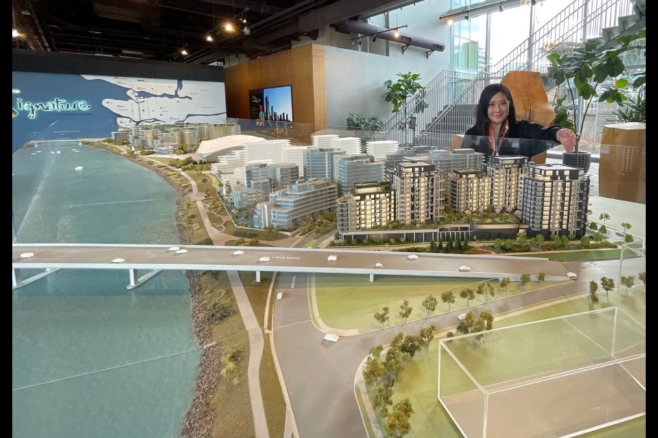 Alice Lam, director of sales and marketing with ASPAC, shows the model of the River Green development next to the Olympic Oval.