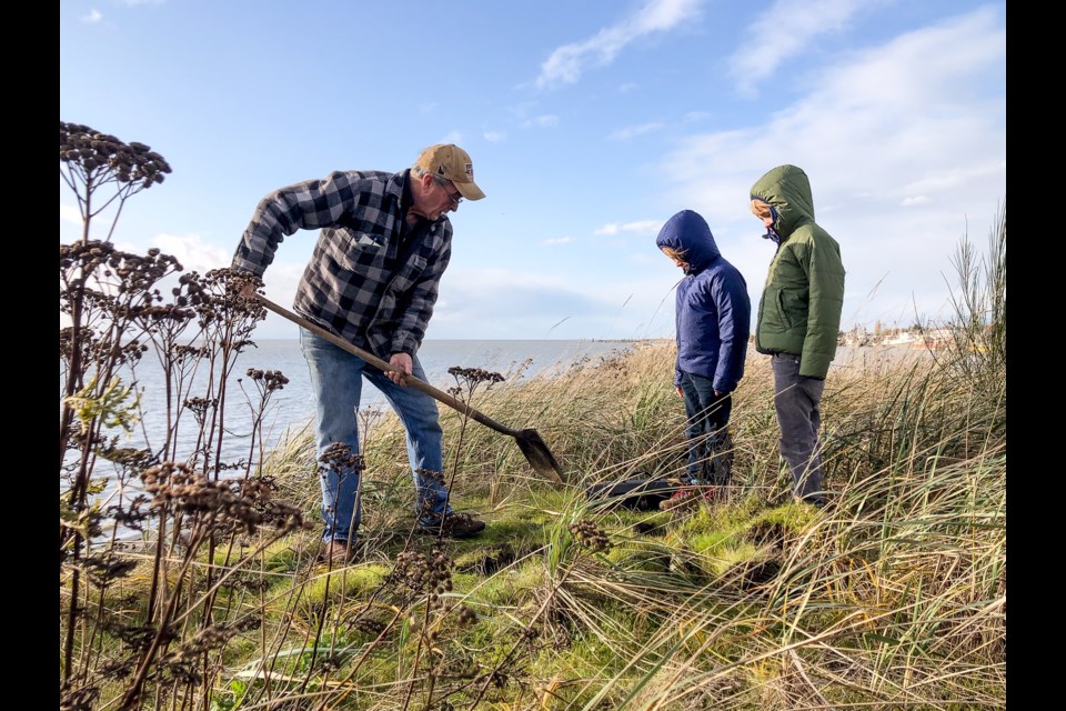 Ken Frail, left, helping his grandchildren dig up the hidden treasure.