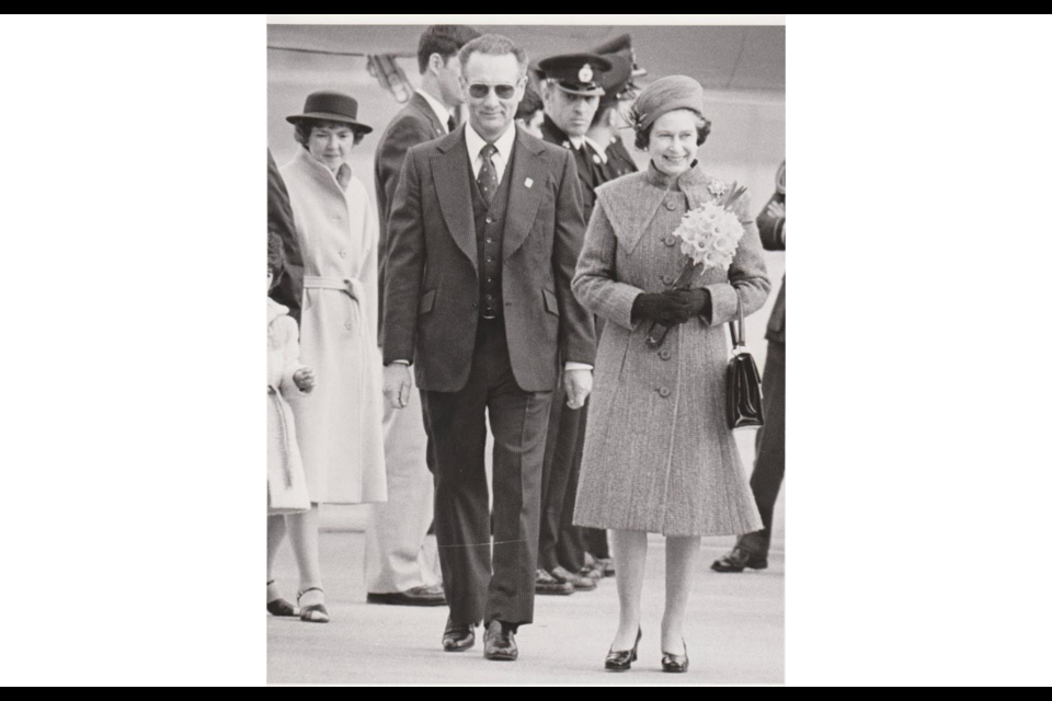 The Richmond mayor of the day, Gil Blair, escorts Queen Elizabeth II off the tarmac at Vancouver Airport