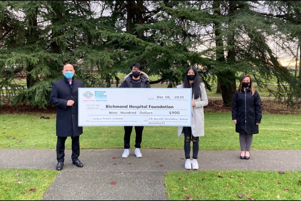 Josh Zheng and Coey Wong, and their classmates, raised $900 for the Richmond Hospital Foundation through two fundraising projects, which they launched as part of their Grade 11 marketing class. From left to right: Jim Bindon, Director of Philanthropy, Richmond Hospital Foundation; Josh Zheng, co-CEO of Marketing B2 Venture and Burnett secondary student; Coey Wong, co-CEO of Marketing B2 Venture and Burnett secondary student; Wennie Walker, Principal, Burnett secondary