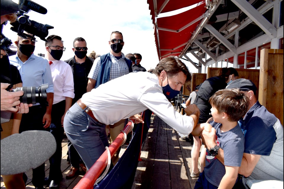 Liberal leader Justin Trudeau greets a young "fan" dining at the wharf in Steveston on Wednesday, Aug. 25.