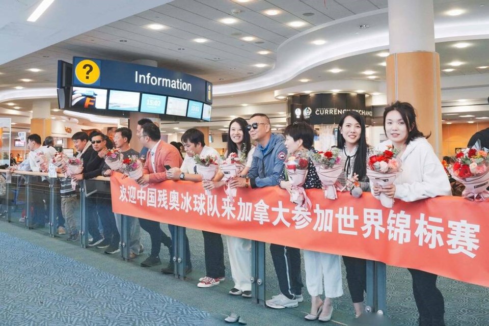 The volunteers welcomed the team with a Chinese-language banner and flowers, and drove them to their hotel in Richmond in a 20-car fleet. Photo credit: Annie Dong