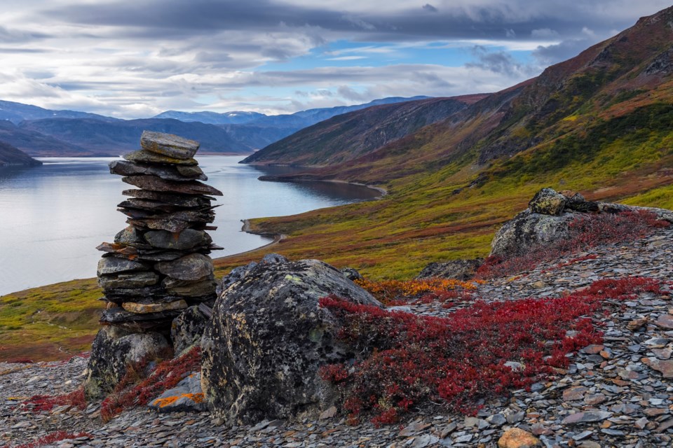 An Inukshuk marks a path from the shoreline upwards to the Chert outcrop rock formations on the far side of the mountain top. This semi-translucent grey stone was highly valued both for its functional but also spiritual properties. It has been found as far west as the Great Lakes and as far south as Chesapeake Bay, suggesting an extensive trading network in ancient times. Ramah Bay, Torngat Mountains National Park, Labrador. SCOTT FORSYTH PHOTO