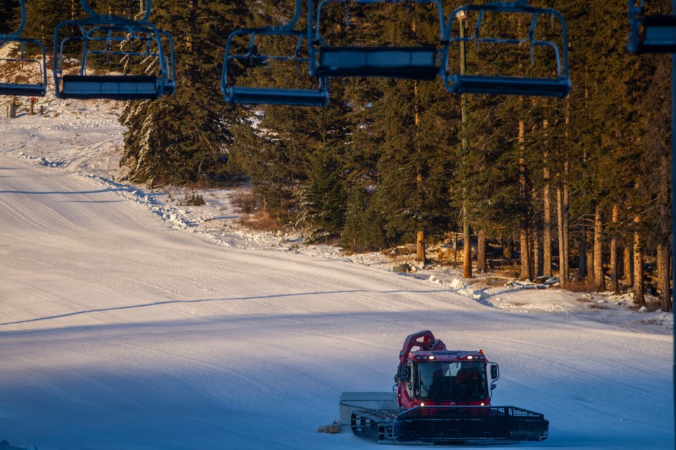 Mt. Norquay snow makers, Arnaud Bourdon, left, and Mike “Radar” Rae walk near a large snow gun before the opening day of the 2019 season at Mt. Norquay. RMO FILE PHOTO