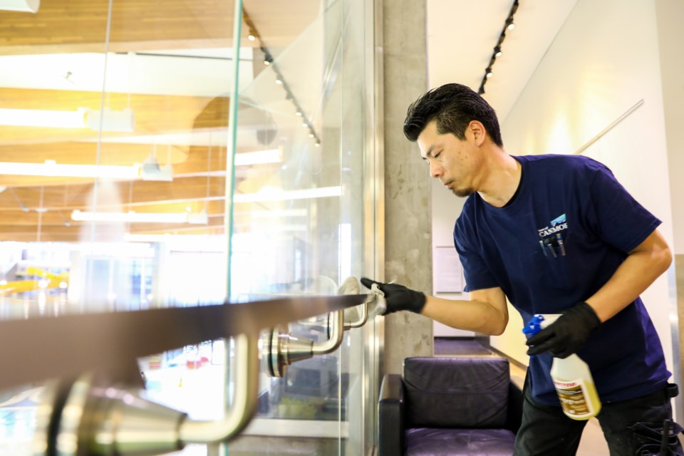 Joe Harasaki an Elevation Place employee sanitizes a hand rail at Elevation Place in response to the novel coronavirus on Friday (March 13). EVAN BUHLER RMO PHOTO⁠