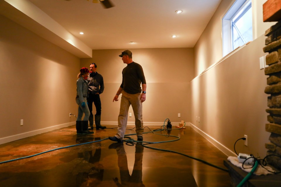 Longtime Exshaw resident Locky Matheson, right, shows the flooding in his basement to MP Blake Richards and MLA Miranda Rosin on June 5, 2020. Richards and Rosin were escorted by MD Bighorn Coun. Paul Ryan around Pigeon Mountain Drive and Mcgillivary Drive. The elected officials spoke to residents affected by the flooding and later met with the MD Bighorn council. EVAN BUHLER RMO PHOTO⁠