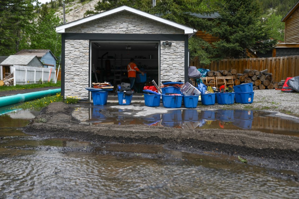 Fergus Sinclair packs his garage belongings in boxes in preparations for higher flood waters in Exshaw on Friday (June 5). Flooding issues started more than 10 days ago and more than 25 homes have been affected in the hamlet. EVAN BUHLER RMO PHOTO⁠